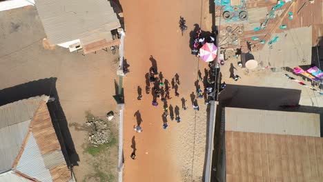 Kinder-Winken,-Als-Eine-Drohne-über-Ihnen-Auf-Einer-Unbefestigten-Straße-In-Westafrika-Abhebt
