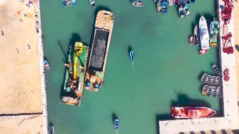 Beautiful-Aerial-Top-Down-View-Of-Blue-Boats-In-The-Harbor-At-Essaouira-Morocco-With-Birds-Flying-Above-1