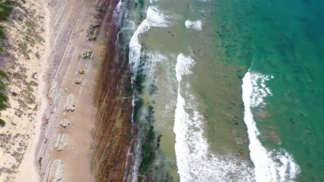 Aerial-Looking-Straight-Down-At-Ocean-Waves-Breaking-On-A-Rocky-Coast-Near-Carpinteria-Santa-Barbara-California