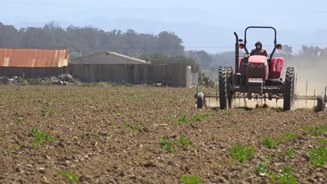 Tractor-Agrícola-Se-Mueve-A-Través-De-Un-Paisaje-Seco-Y-Polvoriento-En-California,-Lo-Que-Sugiere-Sequía-Y-Cambio-Climático-1
