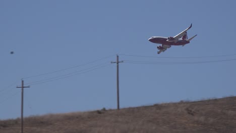 Fixed-Wing-Aircraft-Drops-Fire-Retardant-Phos-Chek-On-A-Brush-Fire-Burning-In-The-Hills-Of-Southern-California-Looks-Like-A-Plane-Crash-Behind-Hillside-1