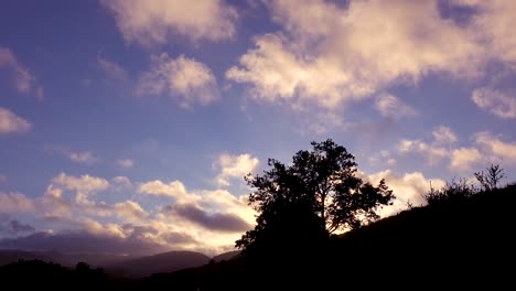 Schöner-Zeitraffer-Von-Wolken,-Die-über-Einen-Bergrücken-Mit-Bäumen-Im-Vordergrund-Wehen