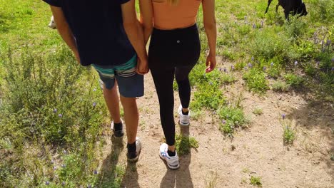 A-Man-And-Woman-Walk-Hand-In-Hand-Holding-Hands-On-A-Hike-In-Slow-Motion