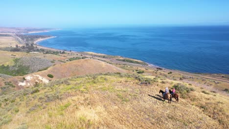 Beautiful-Aerial-Of-Retired-Retirement-Couple-Riding-Horses-Horseback-On-A-Ranch-Overlooking-The-Pacific-Ocean-In-Santa-Barbara-California-5