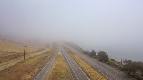 Antena-Sobre-Una-Autopista-Neblinosa-US-101-Pacific-Coast-Highway-Con-Tráfico-A-Lo-Largo-De-La-Costa-De-California