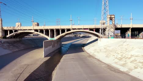 Vista-Aérea-Under-A-Classic-Bridge-Along-The-La-Río-In-Downtown-Los-Angeles-California