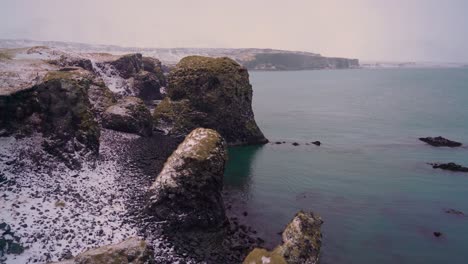 Snow-is-seen-on-the-rocks-of-Arnarstapi-Harbor-on-the-Snaefellsne-Peninsula-of-Iceland