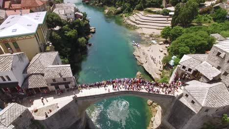 Eine-Vogelperspektive-Zeigt-Menschenmengen,-Die-Sich-Auf-Der-Mostar-Brücke-Und-Dem-Fluss-Neretva,-Den-Sie-In-Mostar-Bosnien-überquert,-Versammelt-Haben