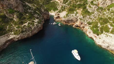 Eine-Luftaufnahme-Zeigt-Segelboote-Und-Touristen-Am-Strand-Von-Stiniva-In-Vis-Kroatien