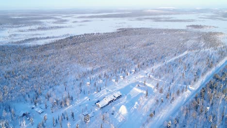 An-Aerial-View-Shows-Trees-And-Lodgings-Of-The-Snowcovered-Northern-Lights-Ranch-In-Kongas-Finland-2