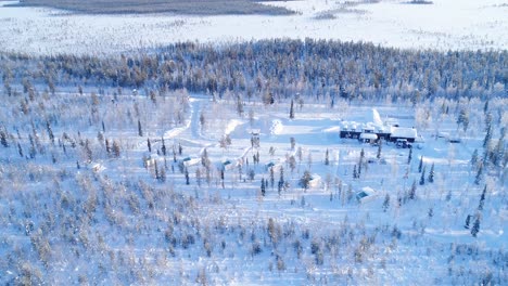 Eine-Luftaufnahme-Zeigt-Bäume-Und-Wohnungen-Der-Schneebedeckten-Nordlichtranch-In-Kongas-Finnland-3