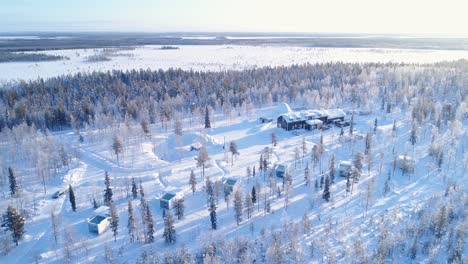 Eine-Luftaufnahme-Zeigt-Bäume-Und-Quartiere-Der-Schneebedeckten-Nordlichtranch-In-Kongas-Finnland-4