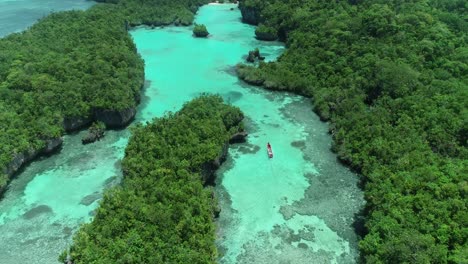 Eine-Luftaufnahme-Zeigt-Ein-Boot,-Das-Sich-Auf-Einer-Wasserstraße-In-Baer-Island,-Indonesien,-Bewegt