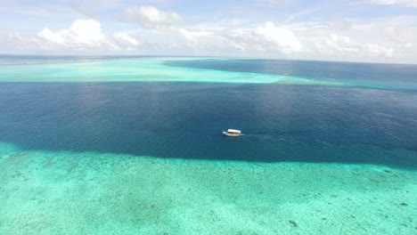 Eine-Luftaufnahme-Zeigt-Ein-Motorboot,-Das-Auf-Den-Malediven-An-Einem-Riff-Entlangfährt