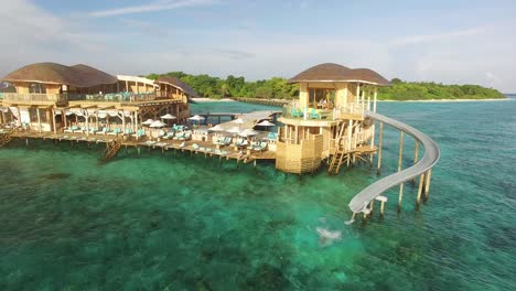 Eine-Frau-Geht-In-Einem-Inselresort-Auf-Den-Malediven-Eine-Wasserrutsche-Hinunter