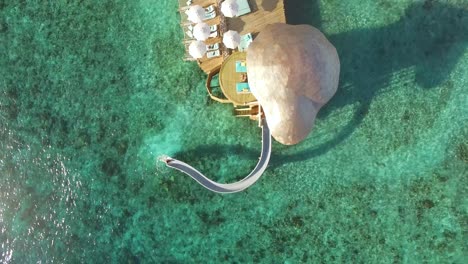 Eine-Vogelperspektive-Zeigt-Eine-Frau,-Die-In-Einem-Inselresort-Auf-Den-Malediven-Eine-Wasserrutsche-Hinunterfährt