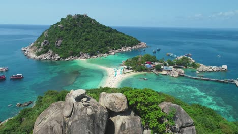 Eine-Luftaufnahme-Zeigt-Boote,-Die-In-Der-Nähe-Verankert-Sind,-Und-Touristen,-Die-Sich-Auf-Den-Miteinander-Verbundenen-Ko-Tao-Inseln-In-Thailand-Entspannen-3
