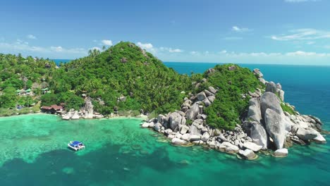 An-Aerial-View-Shows-A-Boat-Anchored-Near-A-Rocky-Harbor-On-Ko-Tao-Thailand
