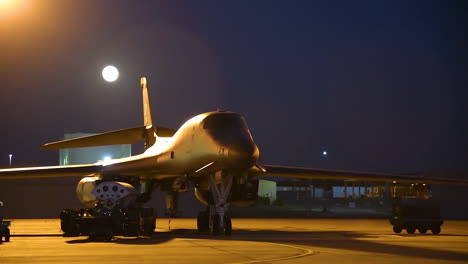 Lapso-De-Tiempo-De-La-Luna-Saliendo-Detrás-De-Un-Bombardero-B1-En-La-Pista-Por-La-Noche