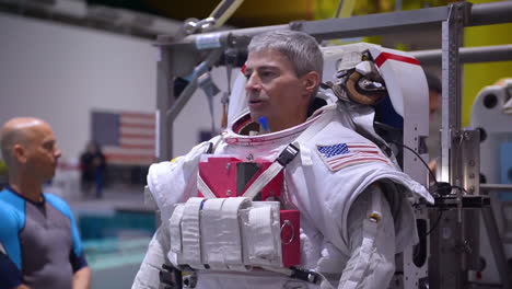 An-Astronaut-Is-Fitted-Into-A-Space-Suit-For-A-Swimming-Pool-Training-Exercise