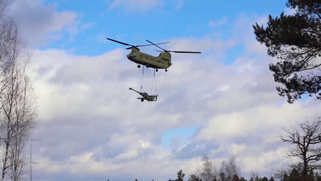 Un-Helicóptero-Del-Ejército-Estadounidense-Transporta-Una-Pieza-De-Artillería-De-Campo-Como-Parte-Del-Ejercicio-De-Frente-Dinámico-En-Alemania