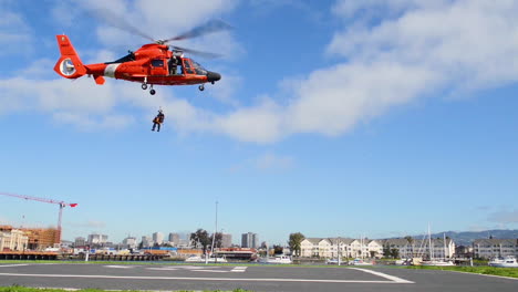 Ein-Unteroffizier-Der-US-Küstenwache-Und-Sein-Hundepartner-Werden-Mit-Einem-Seil-Von-Einem-Hubschrauber-Zum-Stützpunkt-Der-Küstenwache-Alameda-Abgesenkt