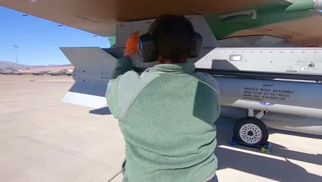 A-Woman-Inspects-A-Military-Jet-At-Nellis-Air-Force-Base-Prior-To-the-Red-Flag-191-Exercise-2019