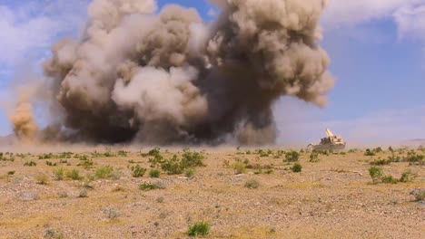 Eine-Riesige-Explosion-Erlischt-Vor-Einem-M1150-angriffsbrecherfahrzeug,-Das-Ein-Schlachtfeld-Für-Minen-Fegt-Nationales-Trainingszentrum-Fort-Irwin-Kalifornien-2019