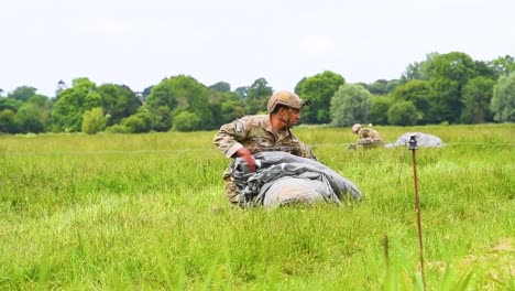 Ein-Gelandeter-Fallschirmjäger-Sammelt-Seinen-Fallschirm-Nach-Der-Landung-Auf-Einem-Feld-In-Der-Nähe-Von-Saintemereeglise,-Frankreich,-Zum-75.-Gedenktag-Am-9.-Juni-2019