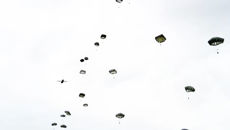 Fallschirmjäger,-Die-Aus-Einem-Flugzeug-Aus-Der-Zeit-Des-Zweiten-Weltkriegs-In-Der-Nähe-Von-Saintemereeglise,-Frankreich,-Zum-75.-Gedenken-An-Den-9.-Juni-2019-Springen