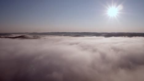 Vista-Aérea-Over-Clouds-And-Mountains-With-the-Sun-In-the-Right-Corner