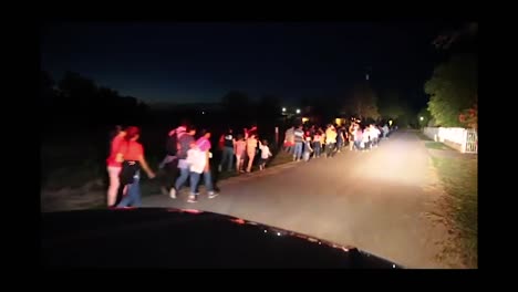 A-Us-Border-Patrol-Car-Drives-Past-Migrants-Walking-In-Los-Ebanos-At-Night