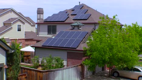 Zoomen-Sie-Aus-Sonnenkollektoren-Heraus,-Die-Die-Dächer-Eines-Hauses-In-Einer-Wohngegend-Schmücken