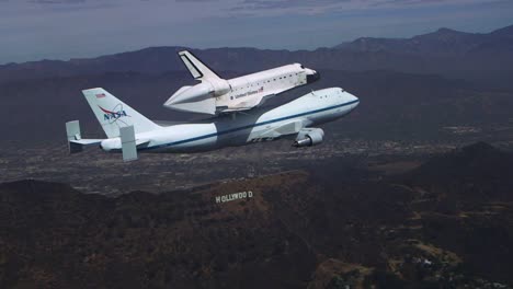 Die-Letzte-Reise-Des-Space-Shuttle-Unternehmens,-Das-über-Die-Innenstadt-Von-Los-Angeles-Und-Das-Hollywood-Schild-Fliegt