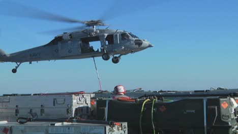 A-Navy-Helicopter-Lifts-Items-Off-The-Deck-Of-An-Aircraft-Carrier-During-A-Operation-2