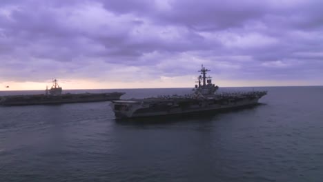 Aerial-Over-Two-Aircraft-Carriers-On-The-High-Seas-With-Helicopter-Moving-Between-1