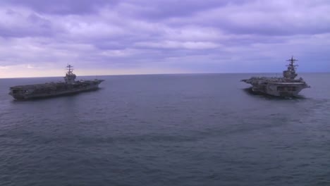 Aerial-Over-Two-Aircraft-Carriers-On-The-High-Seas-With-Helicopter-Moving-Between-2