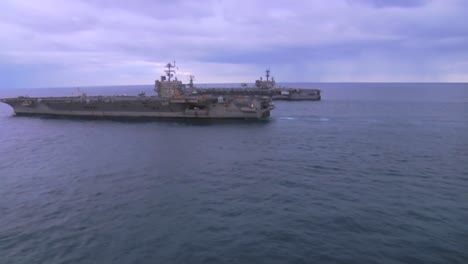 Aerial-Over-Two-Aircraft-Carriers-On-The-High-Seas-With-Helicopter-Moving-Between-3