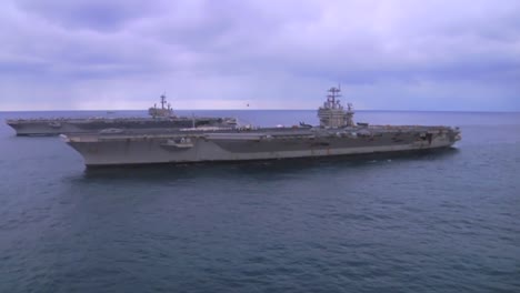 Aerial-Over-Two-Aircraft-Carriers-On-The-High-Seas-With-Helicopter-Moving-Between-4