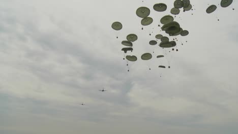 Ground-Angle-View-Of-Supplies-Airdropped-And-Parachuting-To-Earth-From-A-C17