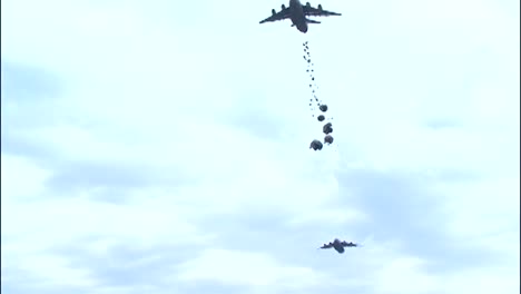 Ground-Angle-View-Of-Paratroopers-Airdropped-And-Parachuting-To-Earth-From-A-C17