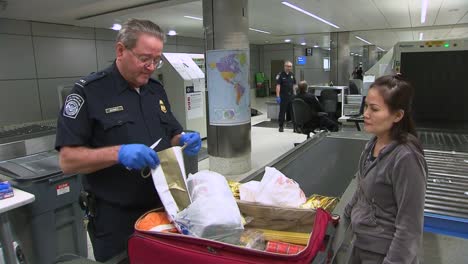 Los-Pasajeros-Que-Ingresan-A-Una-Terminal-De-Aeropuerto-Internacional-Tienen-Su-Equipaje-Inspeccionado-Por-La-Aduana-De-EE.-UU.