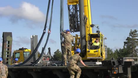 A-Crane-Prepares-To-Lift-A-Trailer-Of-1158th-Transportation-Company-Of-Wisconsin-National-Guard-Onto-A-Rail-Car-1