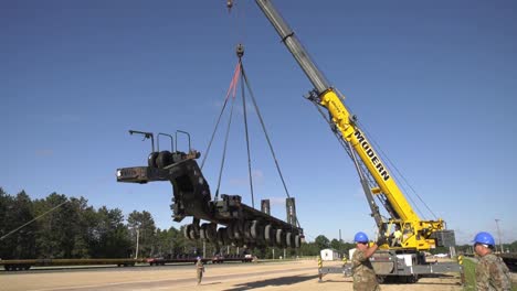 A-Crane-Prepares-To-Lift-A-Trailer-Of-1158th-Transportation-Company-Of-Wisconsin-National-Guard-Onto-A-Rail-Car-3