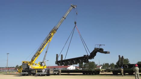 A-Crane-Prepares-To-Lift-A-Trailer-Of-1158th-Transportation-Company-Of-Wisconsin-National-Guard-Onto-A-Rail-Car-4