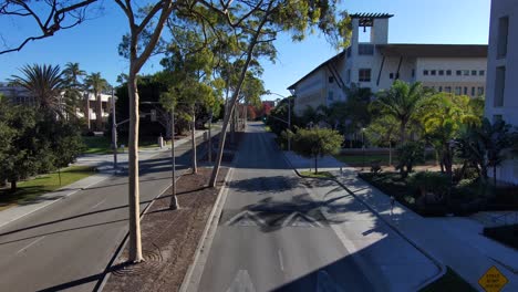 Aerial-down-street-or-boulevard-at-University-of-California-Santa-Barbara-UCSB-campus