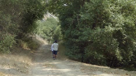 A-Braille-Institute-teacher-helps-a-blind-student-use-her-white-cane-to-walk-on-a-dirt-road-in-the-woods-California