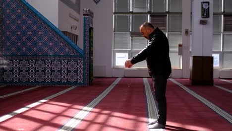 Older-Muslim-Man-Prays-in-Mosque-in-the-Sunlight