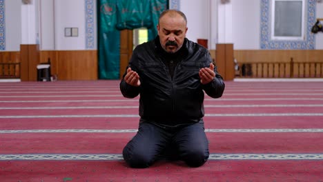 Hombre-Levantando-Las-Manos-Y-Rezando-En-La-Mezquita