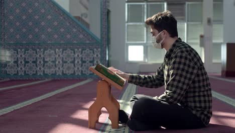 Muslim-Man-In-Mask-In-Mosque-Reading-The-Quran